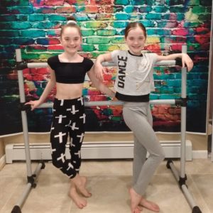 girls on barre in front of backdrop