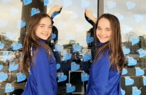 Girls pointing to hearts at dance studio