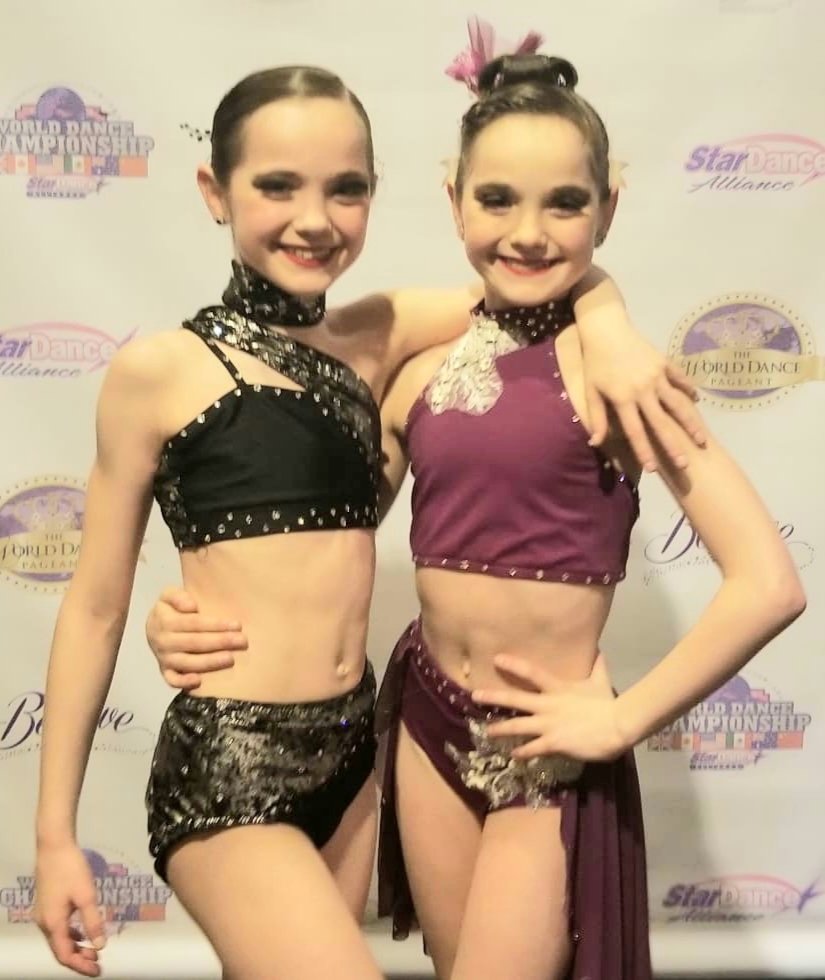 Girls posing after solos at dance competition